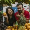 Group tasting tropical fruits like lulo, guanabana, and pitaya at Medellin market