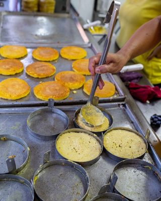 Local vendor serving arepa de chocolo in Medellin city center