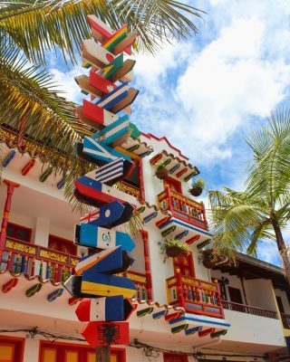 Visitors exploring Guatape’s vibrant town square and murals.