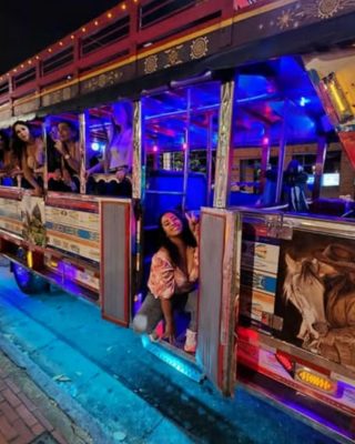 Friends dancing and celebrating on a Chiva bus in Medellin.