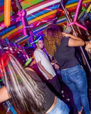Tourists enjoying drinks and music on a Medellin Chiva tour.