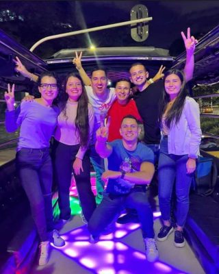 Friends enjoying cocktails and music on a Medellin party bus.